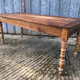 Antique farmhouse table in solid cherry wood with turned legs.
