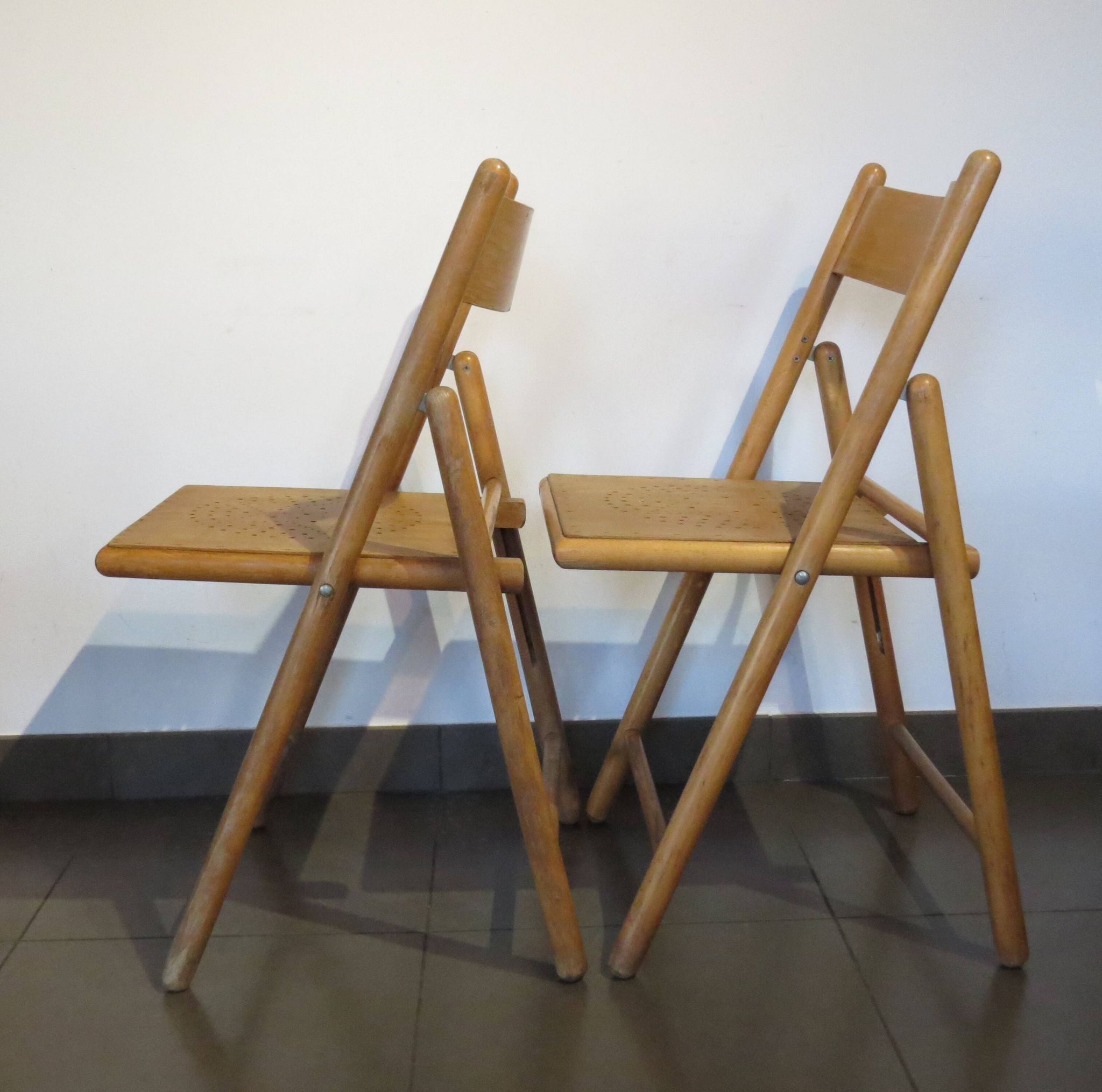 Pair of vintage wooden folding chairs with star pattern on seat