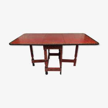 Painted wooden gateleg table with flower decorations on a red background