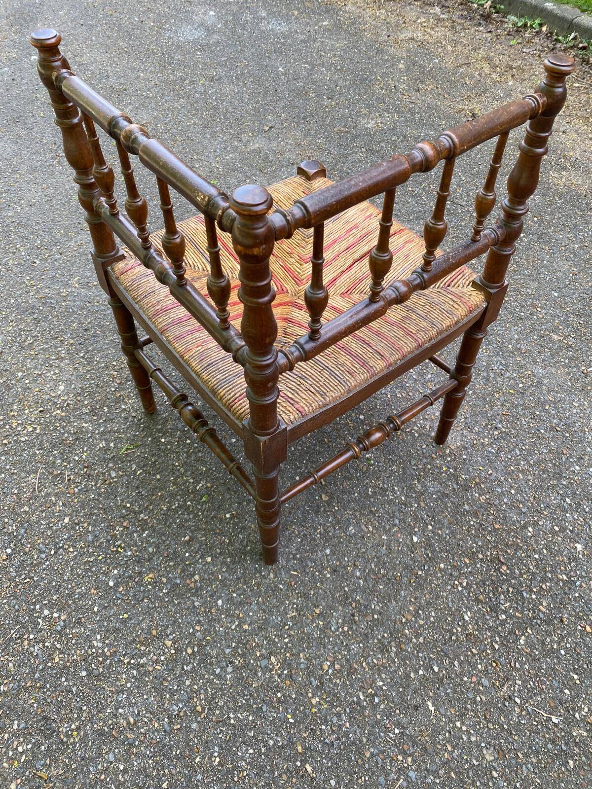 19th-century solid wood corner chair with red and blue rush seating.