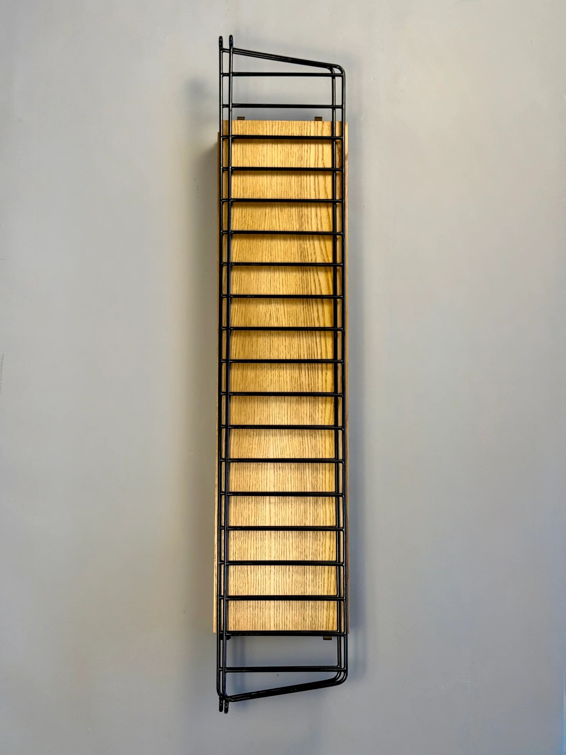 Floating wall shelf in oak veneer and black metal, 1960s.