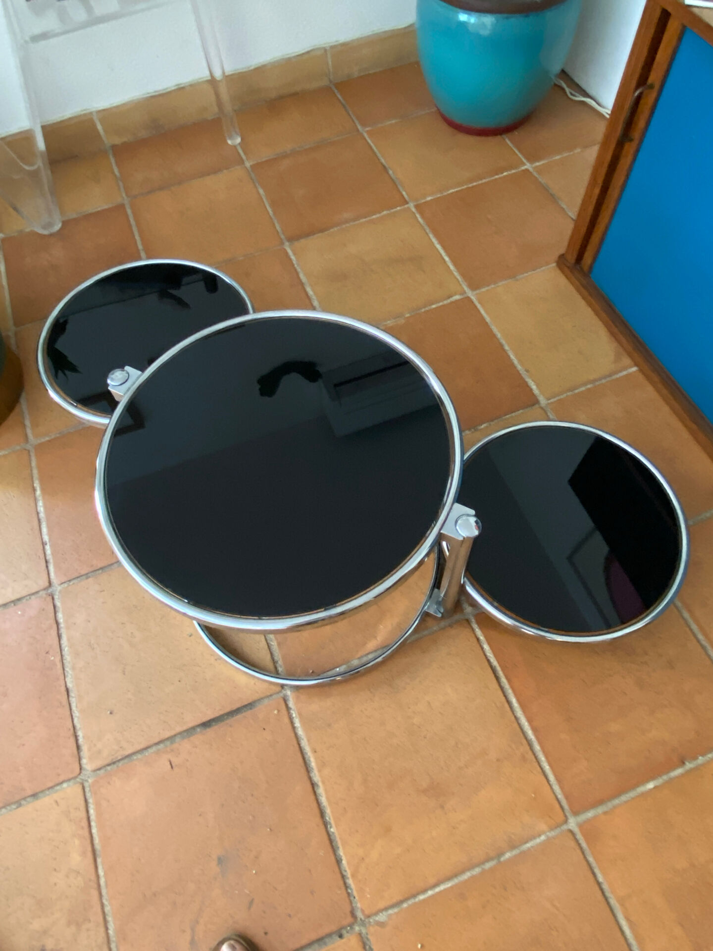 Coffee table with pivoting metal and black glass elements.