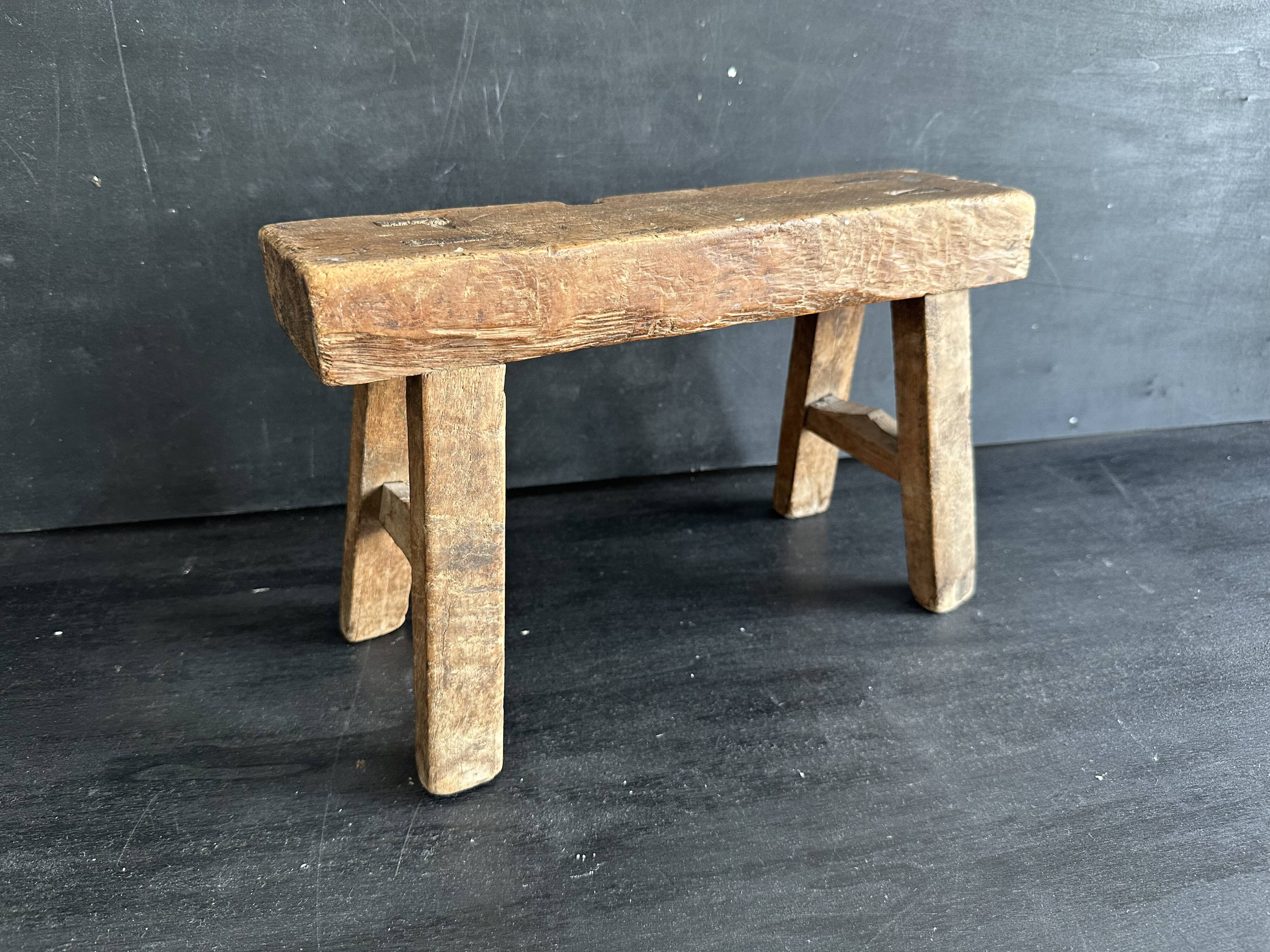 Ancient Chinese farm bench in patinated wood, small rustic stool.