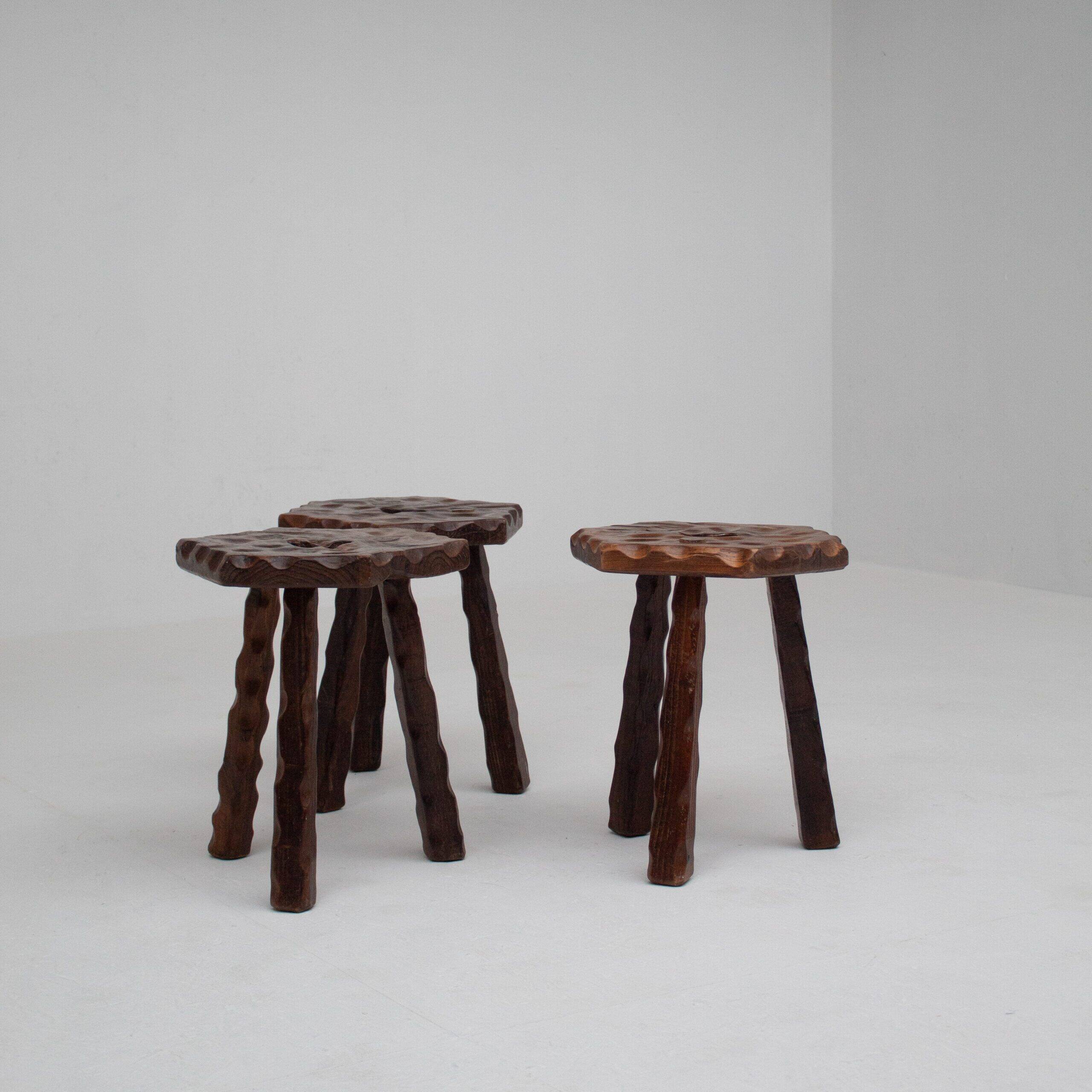 Ensemble de trois tabourets en bois sculptés à la main.