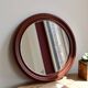 Round vintage mirror with mahogany wood effect frame.