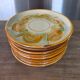 8 vintage dessert plates with a signed decoration.