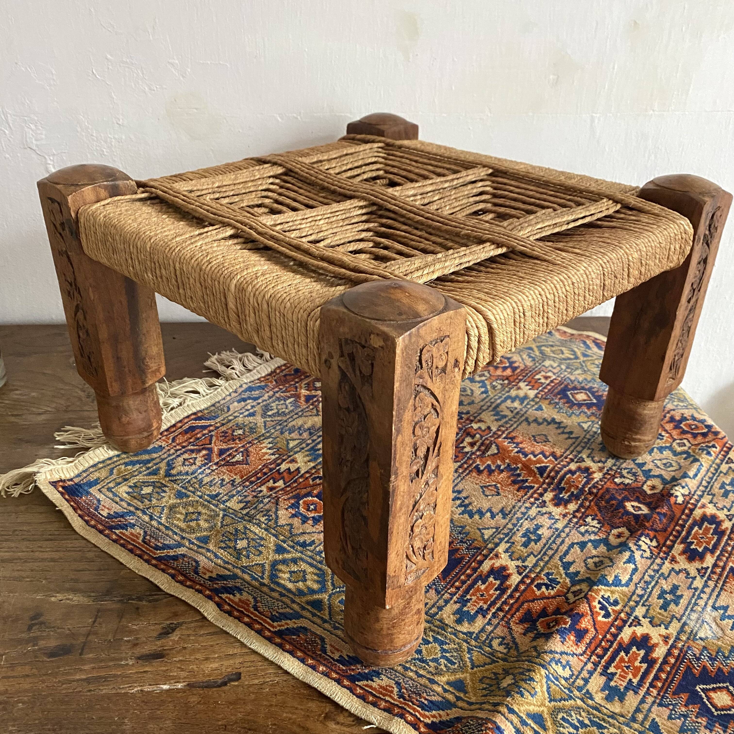 Low stool with carved wood and braided cord.