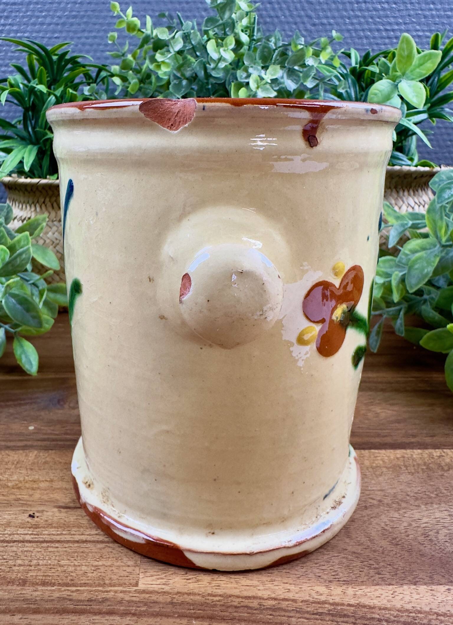Antique ceramic pot with hand-painted floral decoration.