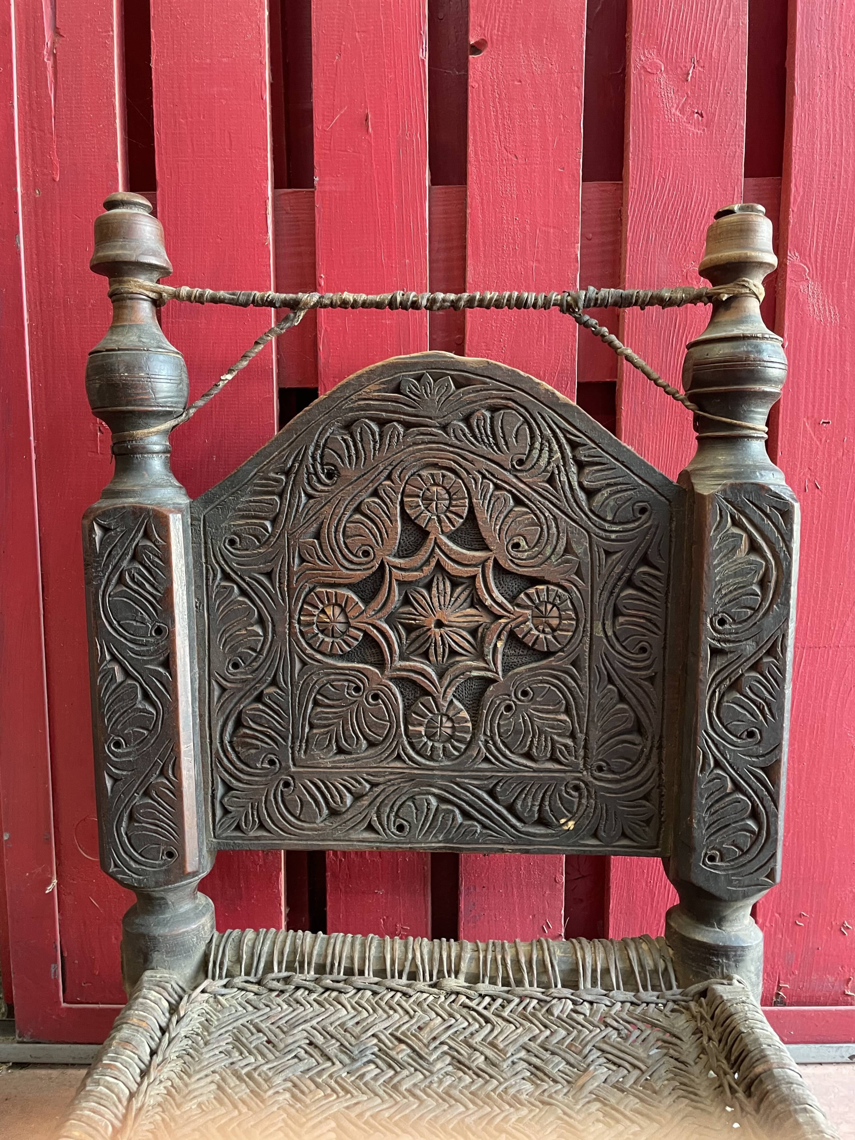 Ancienne chaise basse sculptée en bois de noyer assise tréssée en cuir, Pakistan Vallée de Swat