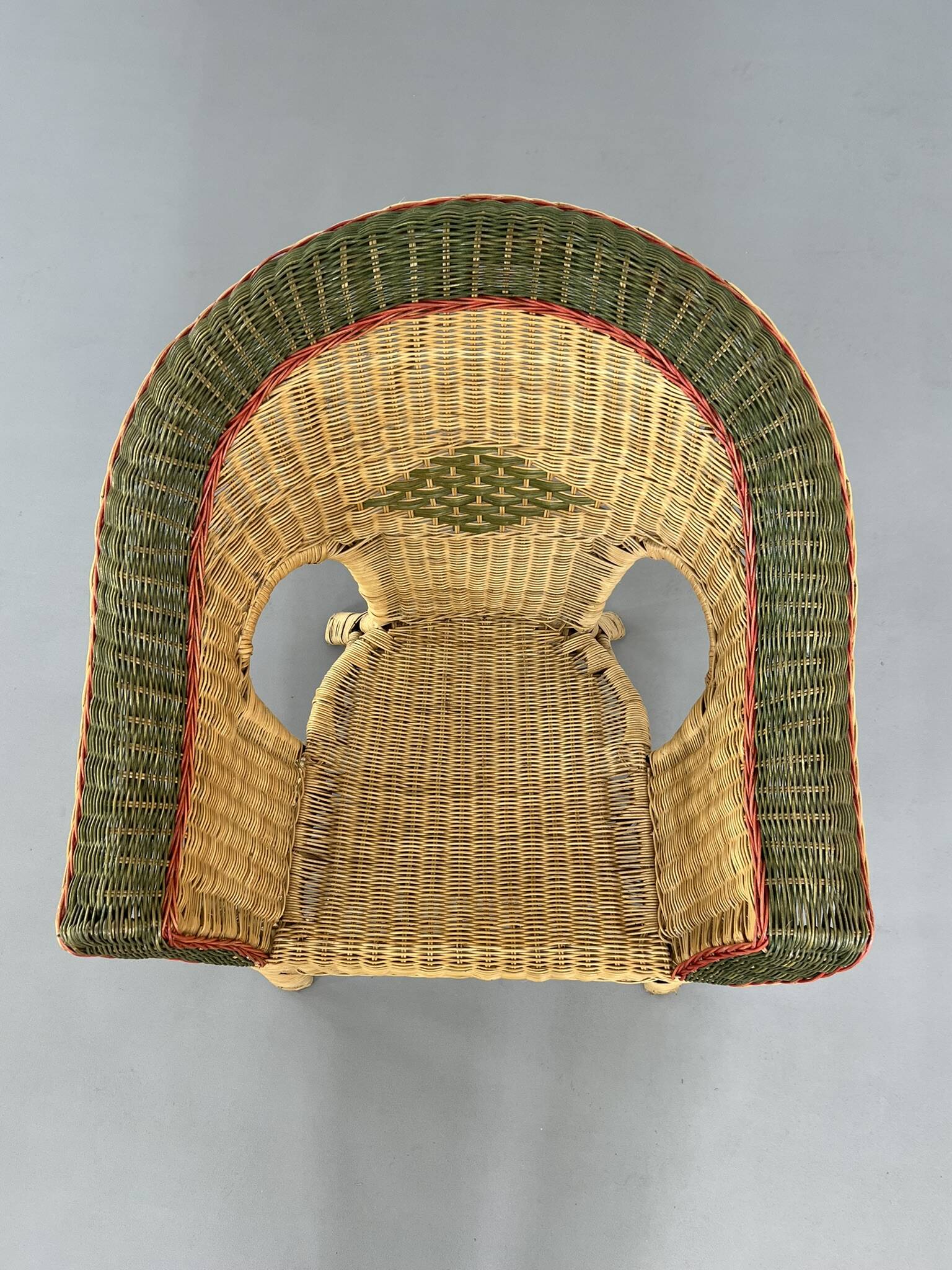 Cabriolet style armchair in rattan, wicker and green and red edging