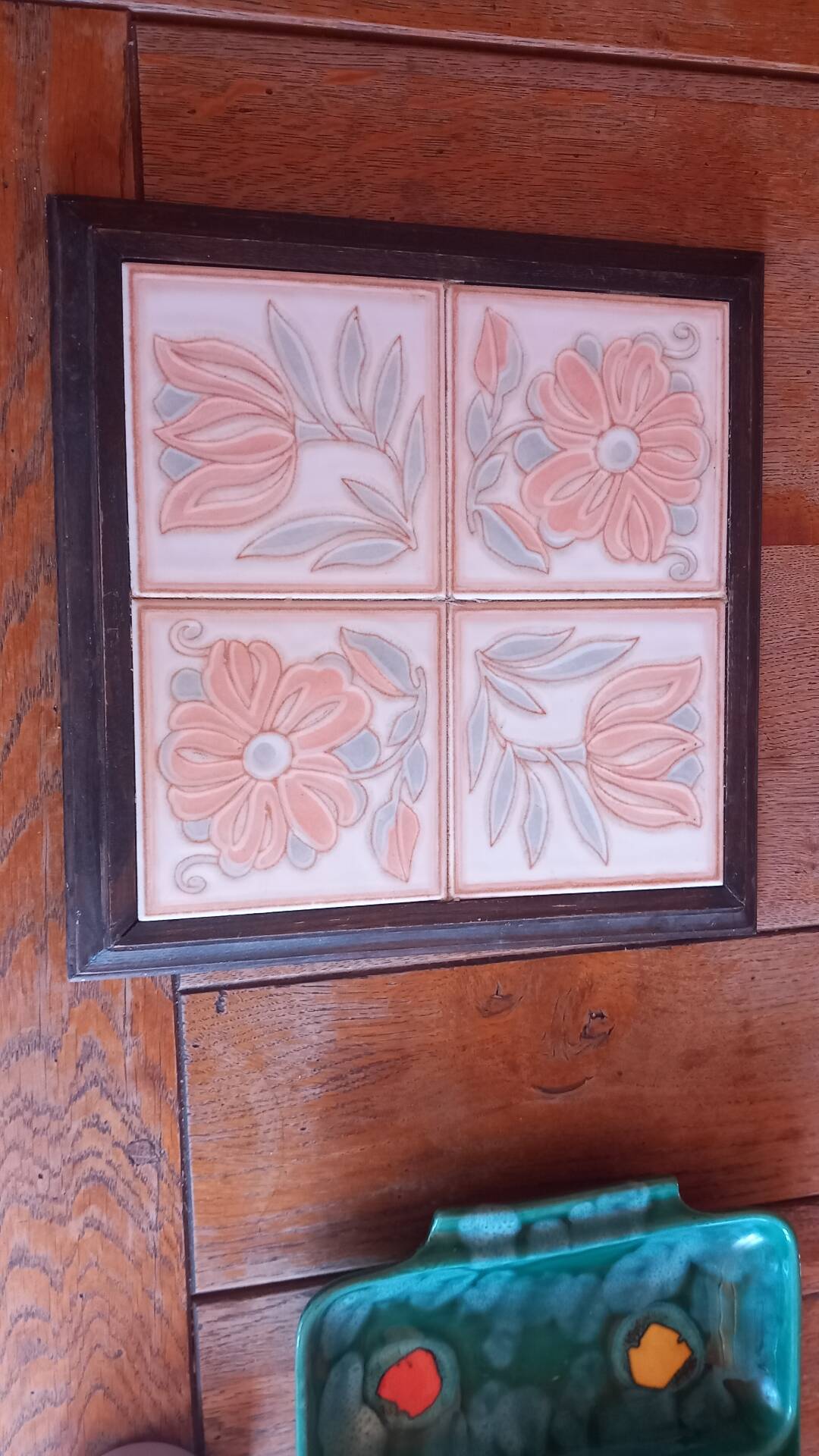 Ceramic tile trivet with floral patterns in pastel tones.