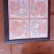Ceramic tile trivet with floral patterns in pastel tones.