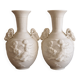 Pair of biscuit vases decorated with putti and ram's head.