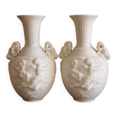 Pair of biscuit vases decorated with putti and ram's head.