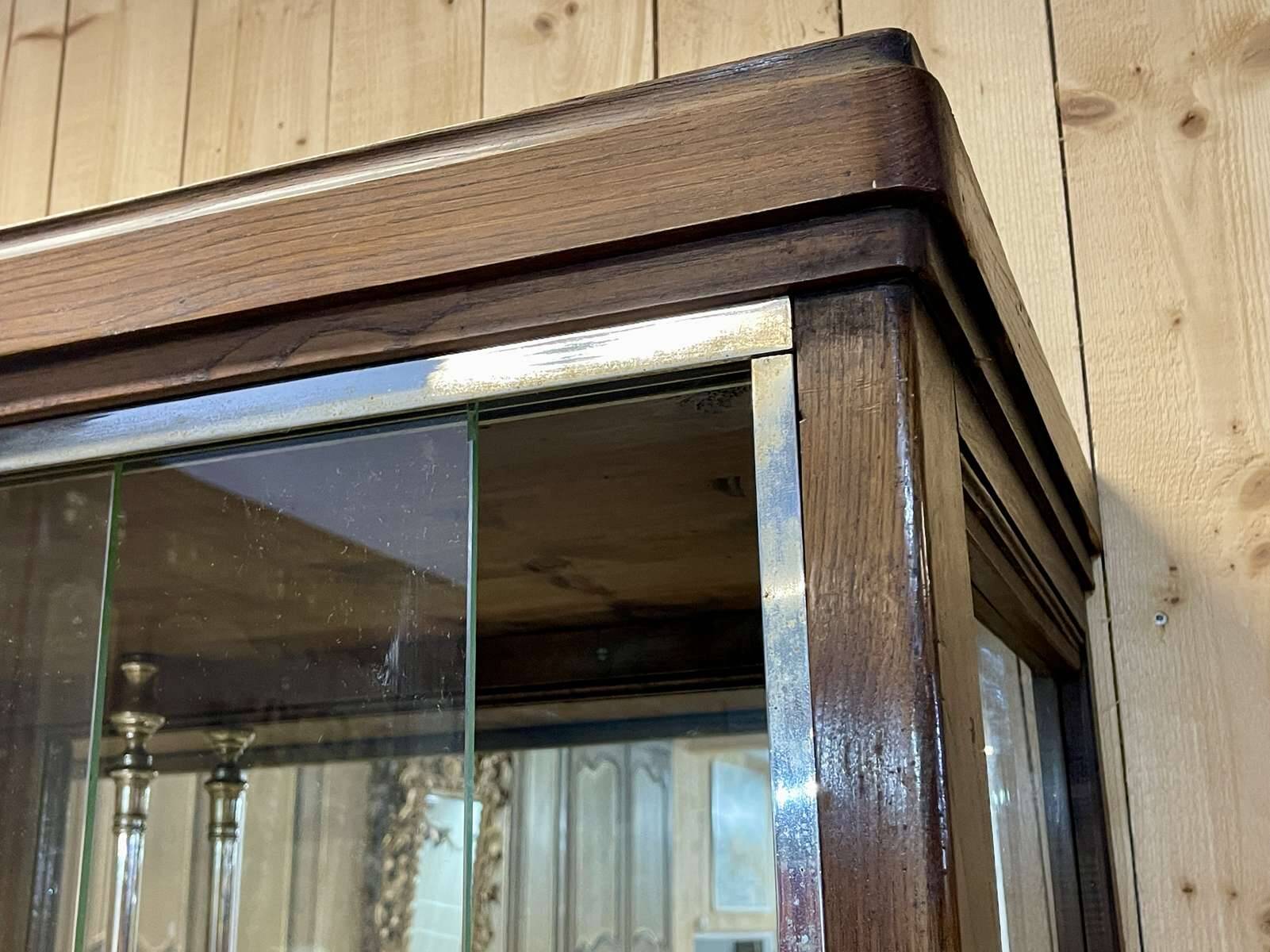 Early 20th-century shop display cabinet in oak with sliding doors.