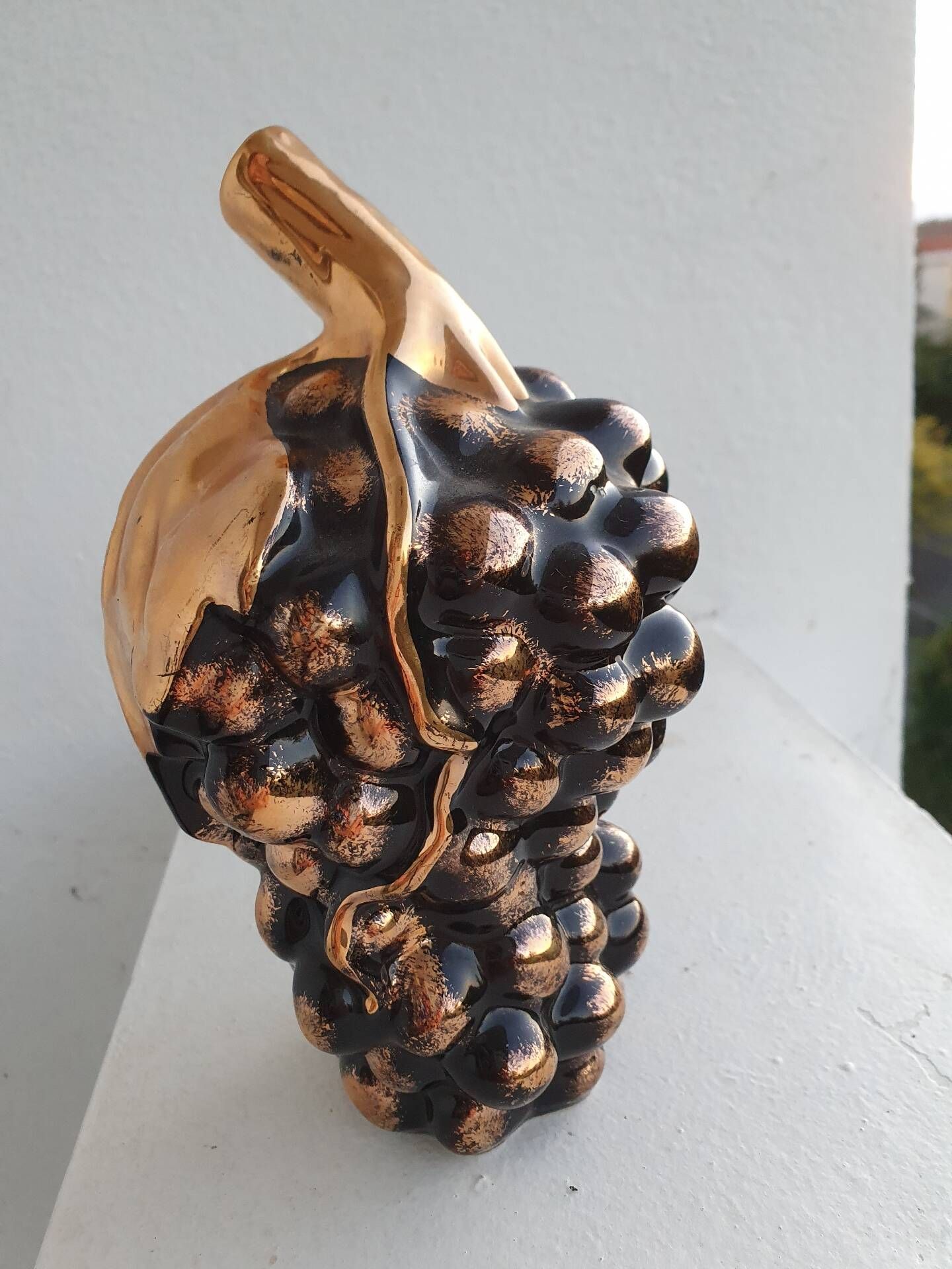 Beautiful black and gold ceramic bottle in the shape of a bunch of grapes.