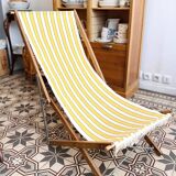 Vintage folding deckchair with yellow striped canvas