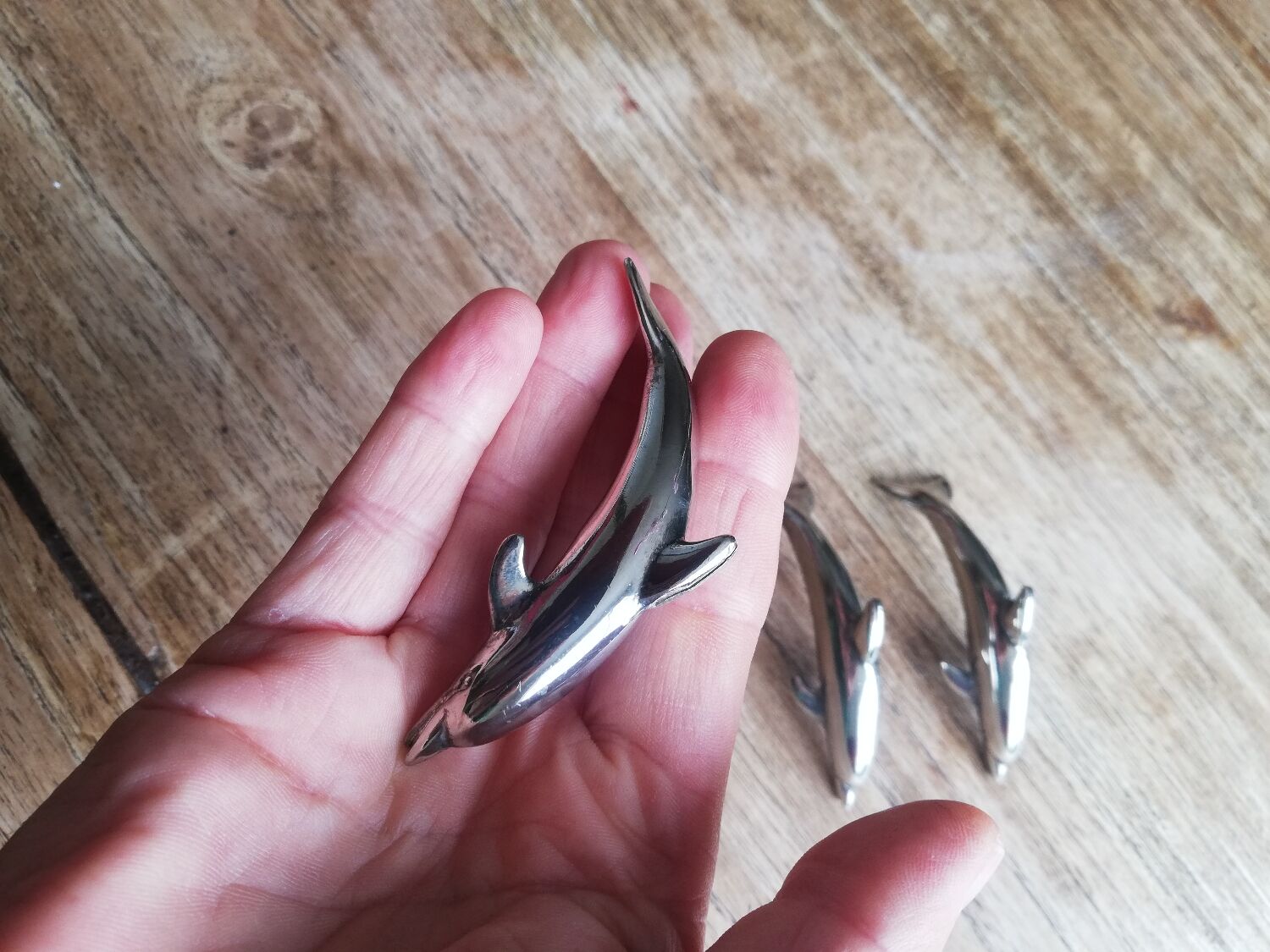 Set of three silver metal dolphin place markers