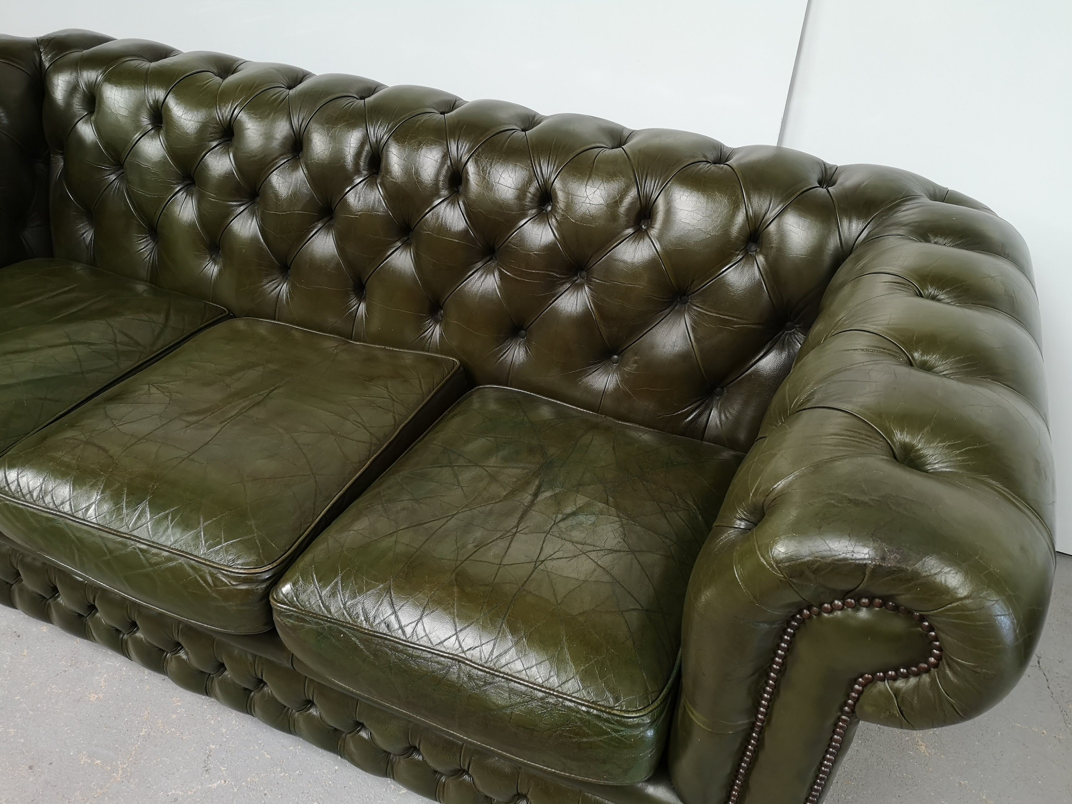 Three-seater green leather Chesterfield sofa