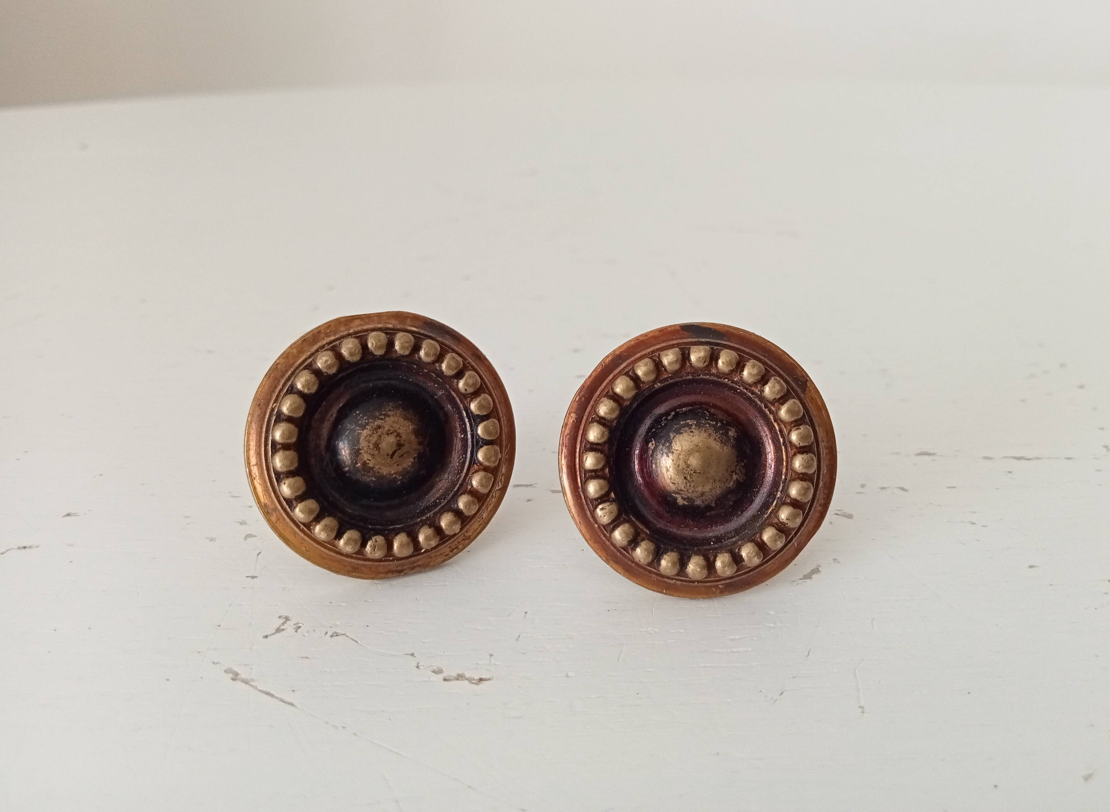 Pair of antique furniture knobs in gilded brass.