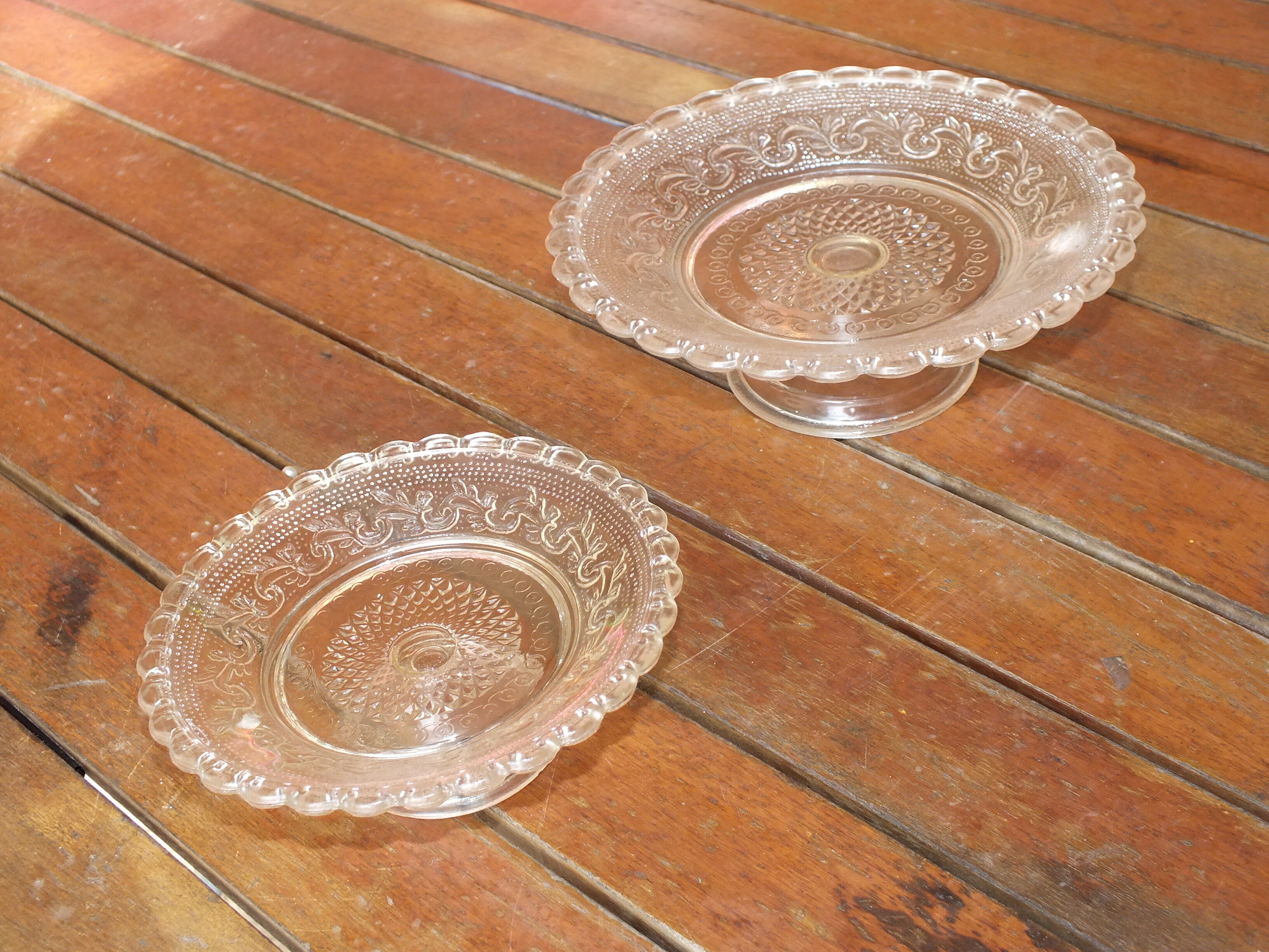Duo of molded glass display cups, arabesque décor