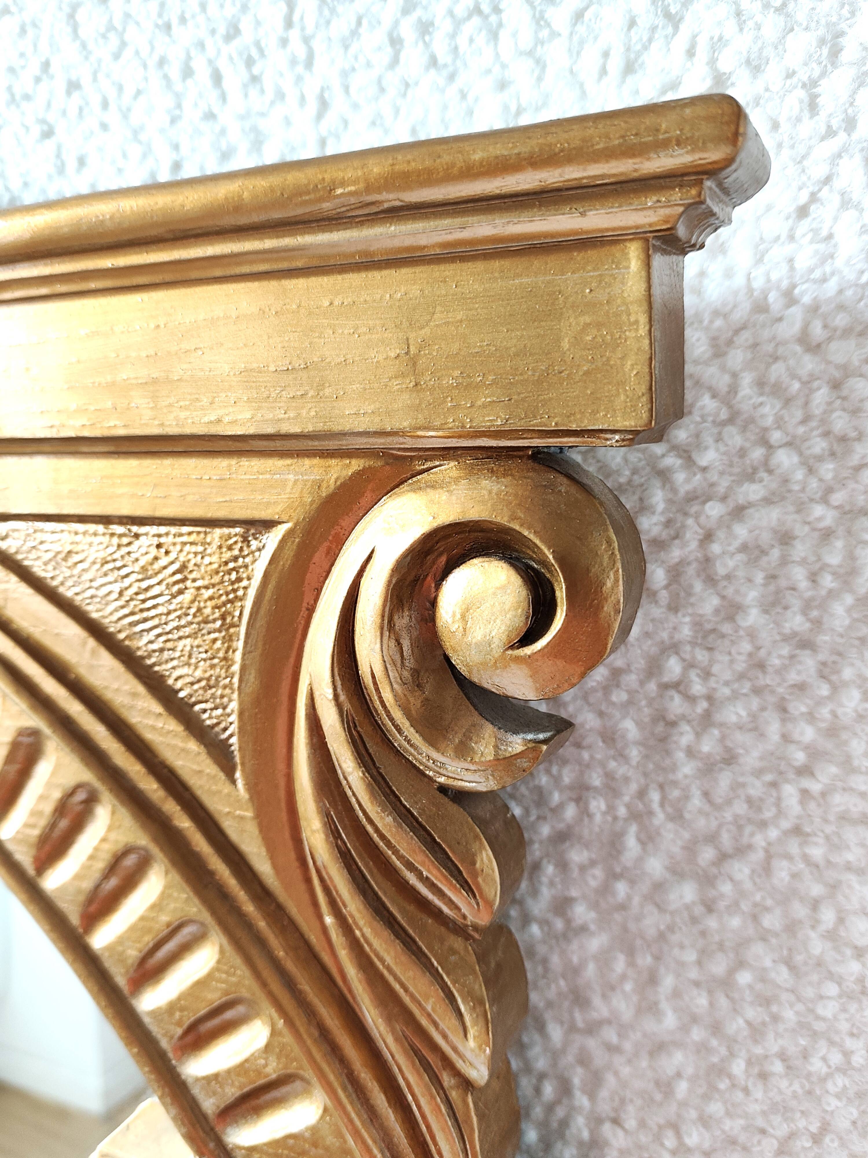 Miroir en bois doré a fronton travaillé
