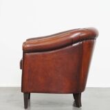 Sheepskin club armchair in a warm deep colour finished with black piping