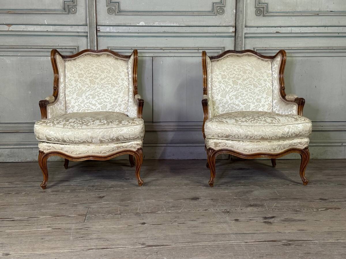Pair of small Louis XV style wing chairs in carved walnut, Bosson stamp