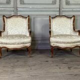 Pair of small Louis XV style wing chairs in carved walnut, Bosson stamp