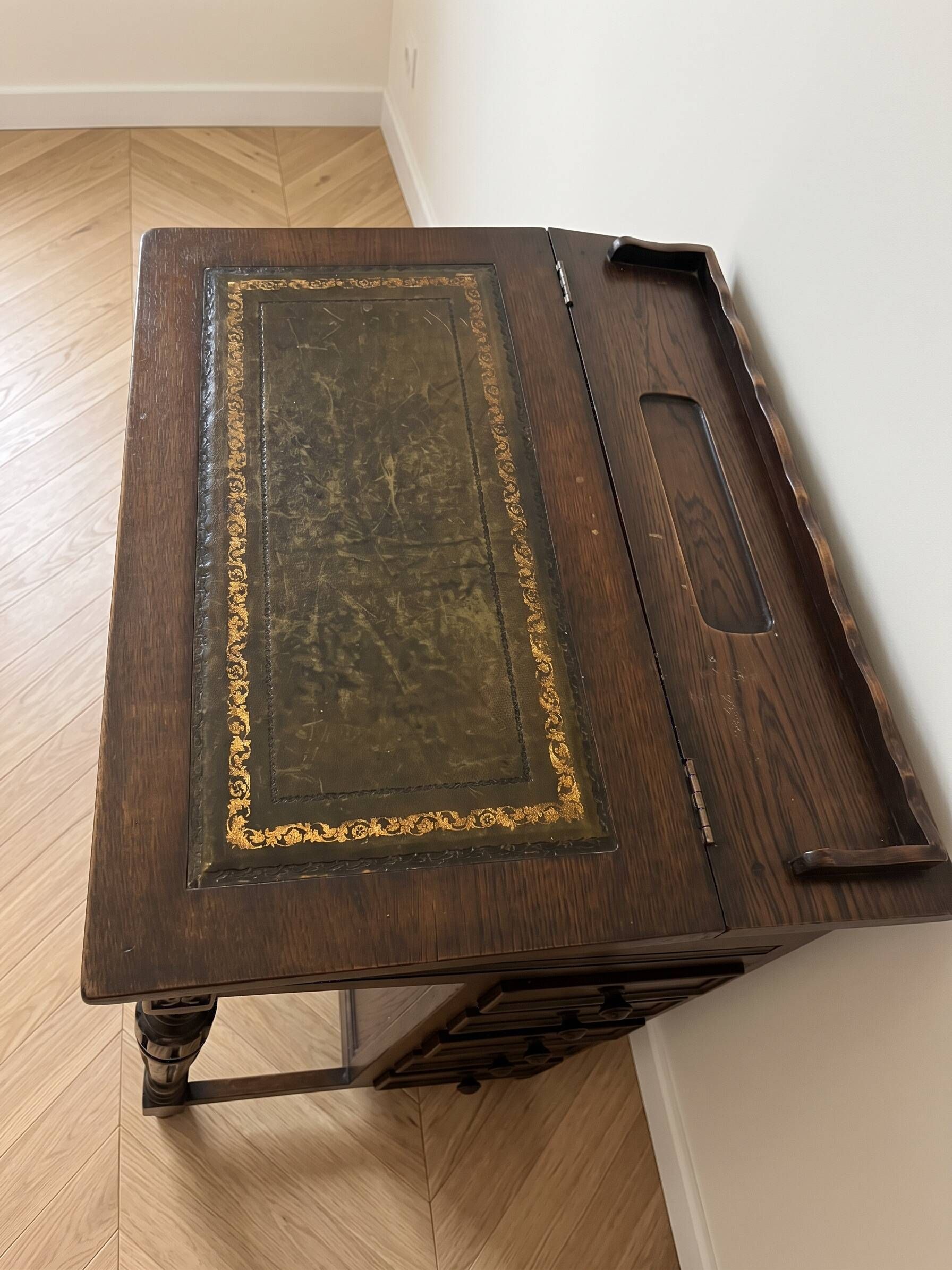 Antique wooden desk with a leather top.
