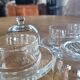 2 transparent glass butter dishes with their matching cloches.