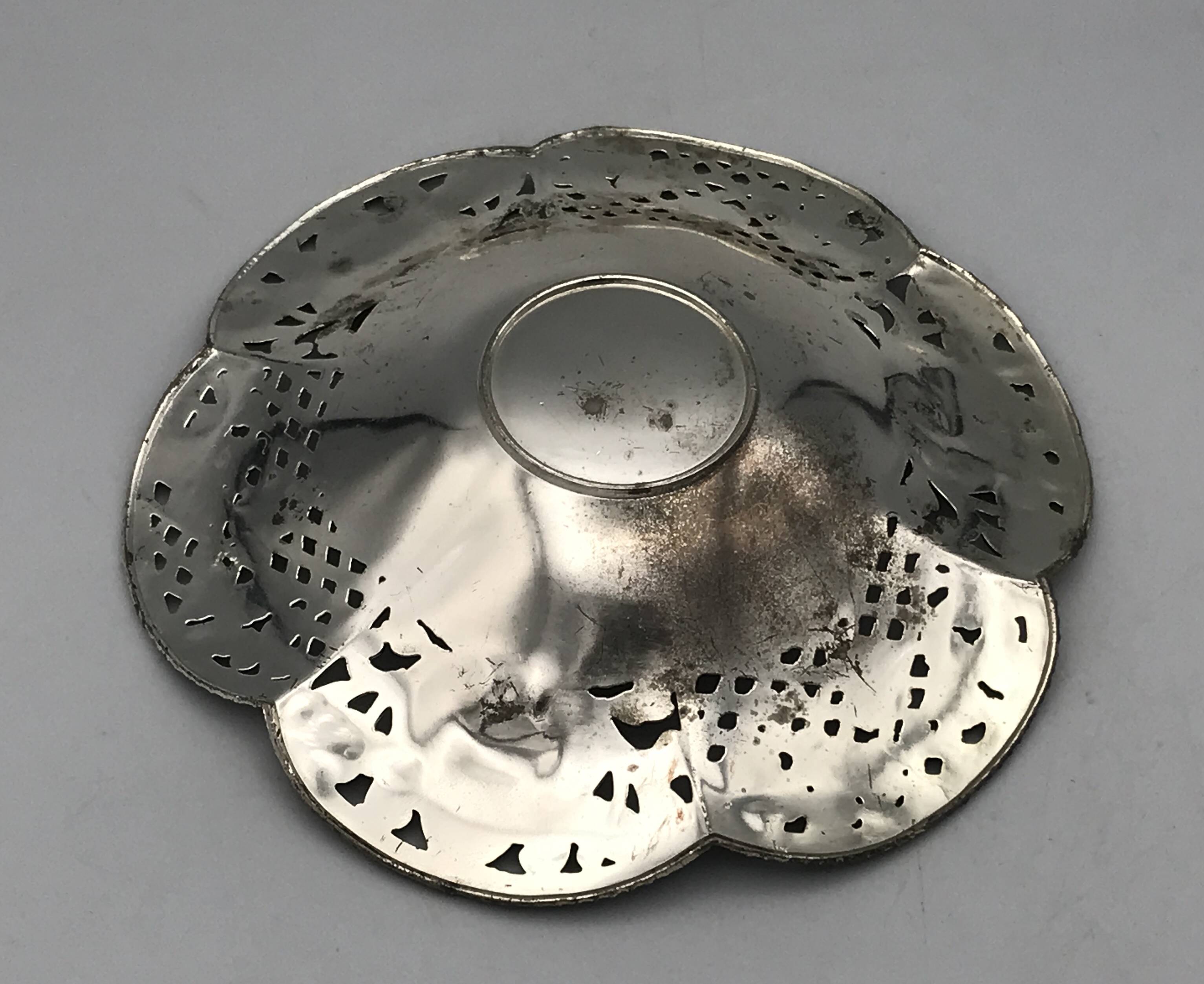 Silver-plated metal pocket emptier with openwork outline decoration