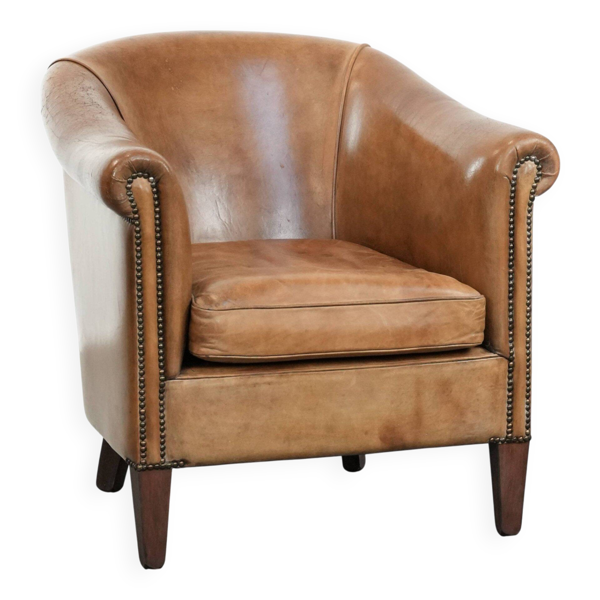 Characterful club chair made of sheepskin leather with light cognac colours