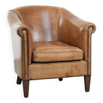 Characterful club chair made of sheepskin leather with light cognac colours