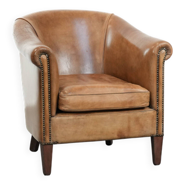 Characterful club chair made of sheepskin leather with light cognac colours