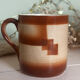 Vintage 70s old ceramic mug with a brown cubic graphic pattern.