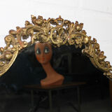 Miroir mural ovale antique dans un cadre en laiton avec ornement supérieur