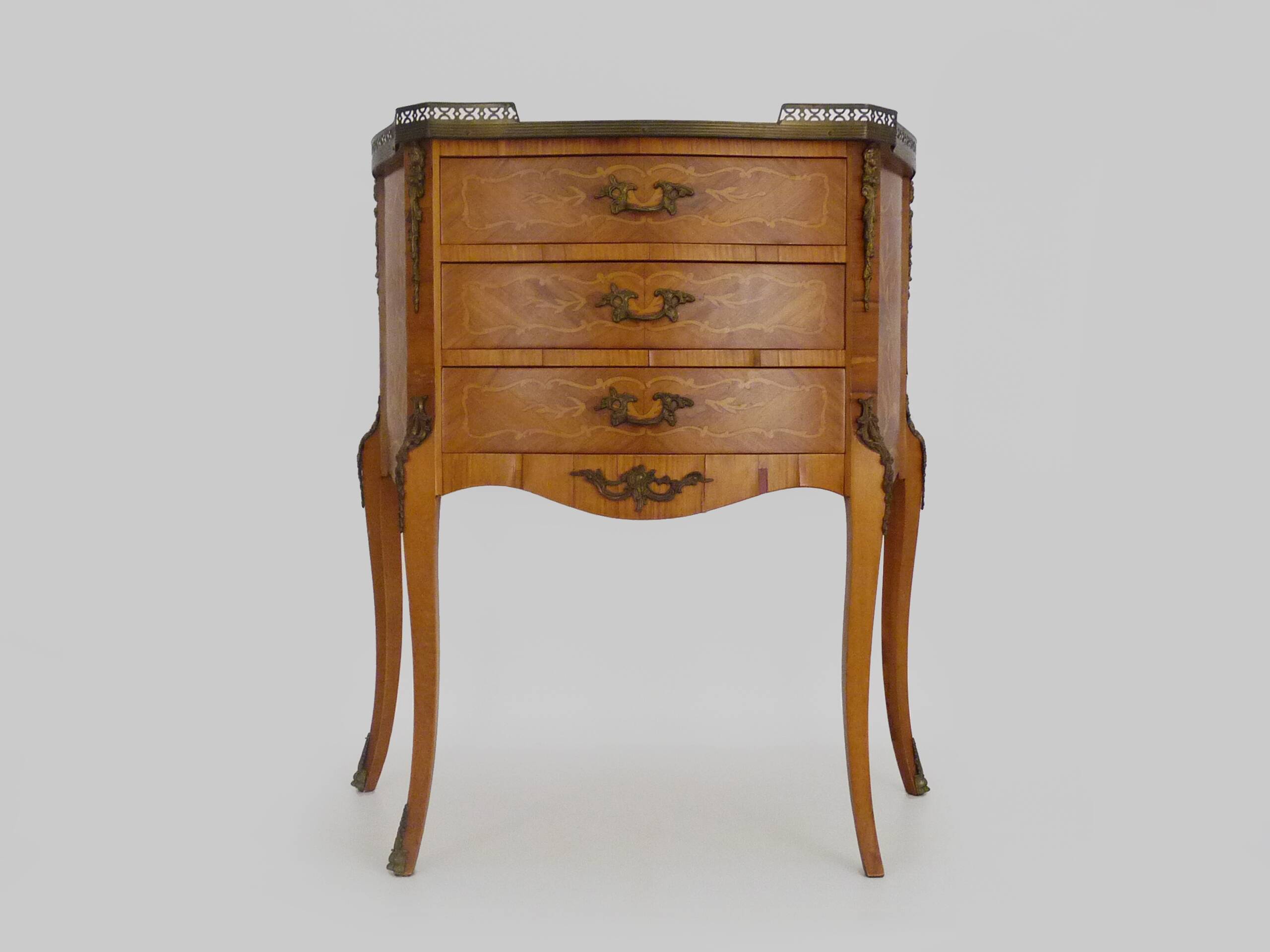 Baroque style wooden chest of drawers with bronze frieze.