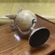 1960s terrestrial globe on a chrome stand with a plane flying over it.