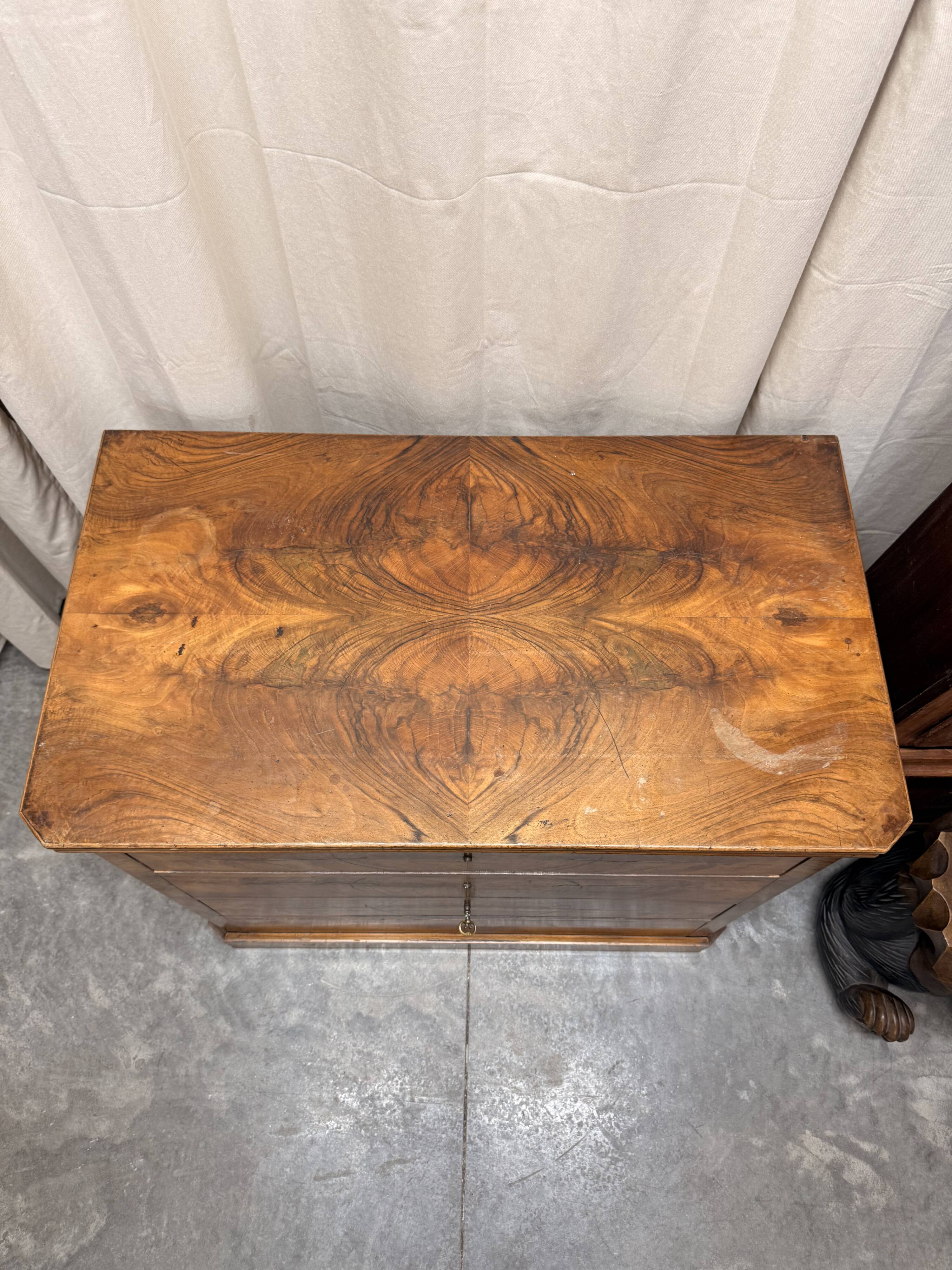 Antique English commode in flame walnut.