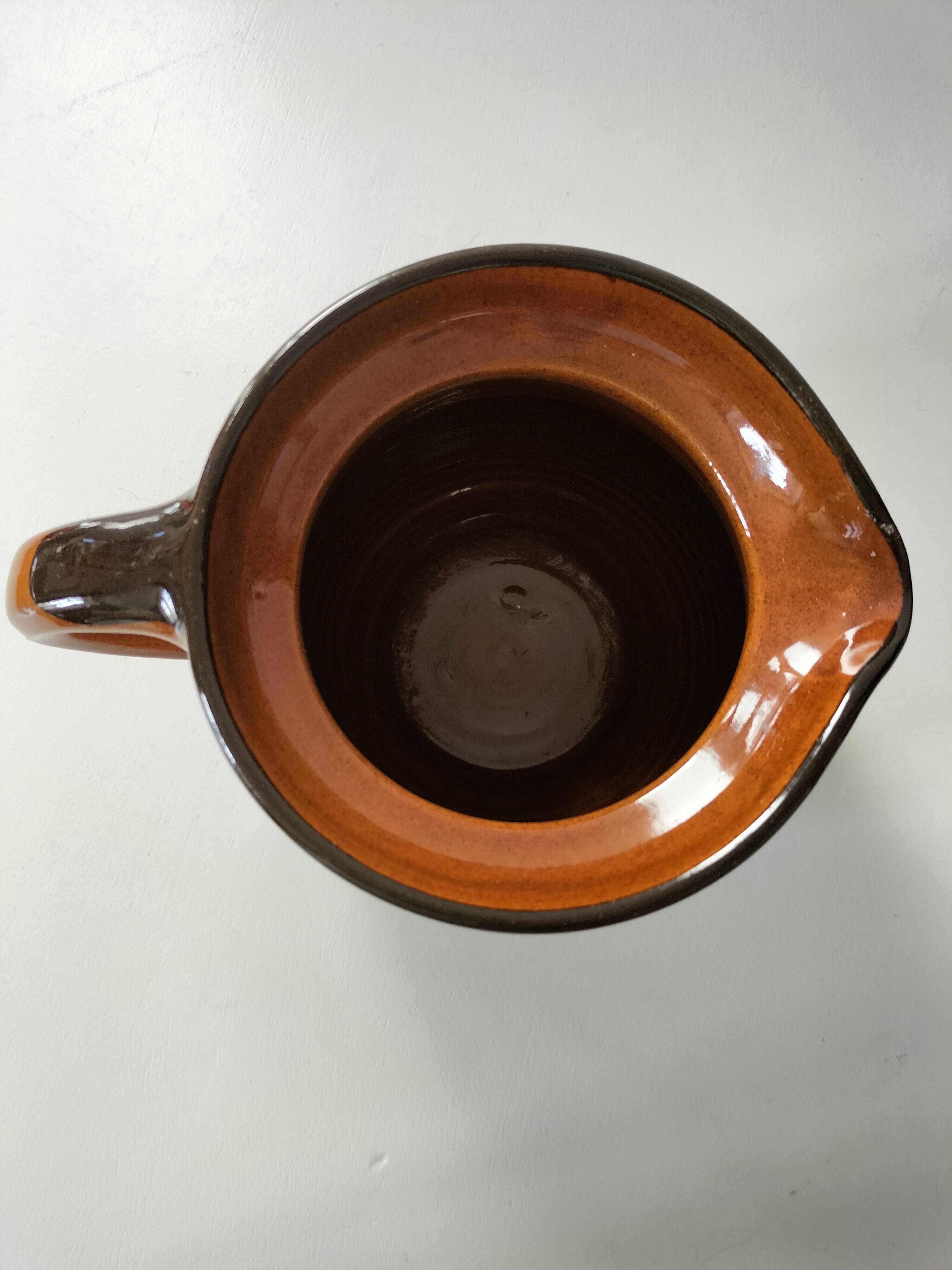 Glazed earthenware pitcher signed HR with a design of stylised birds.