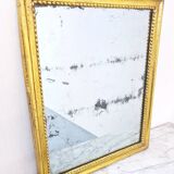 Old mercury mirror in carved wood, gilded with leaf.