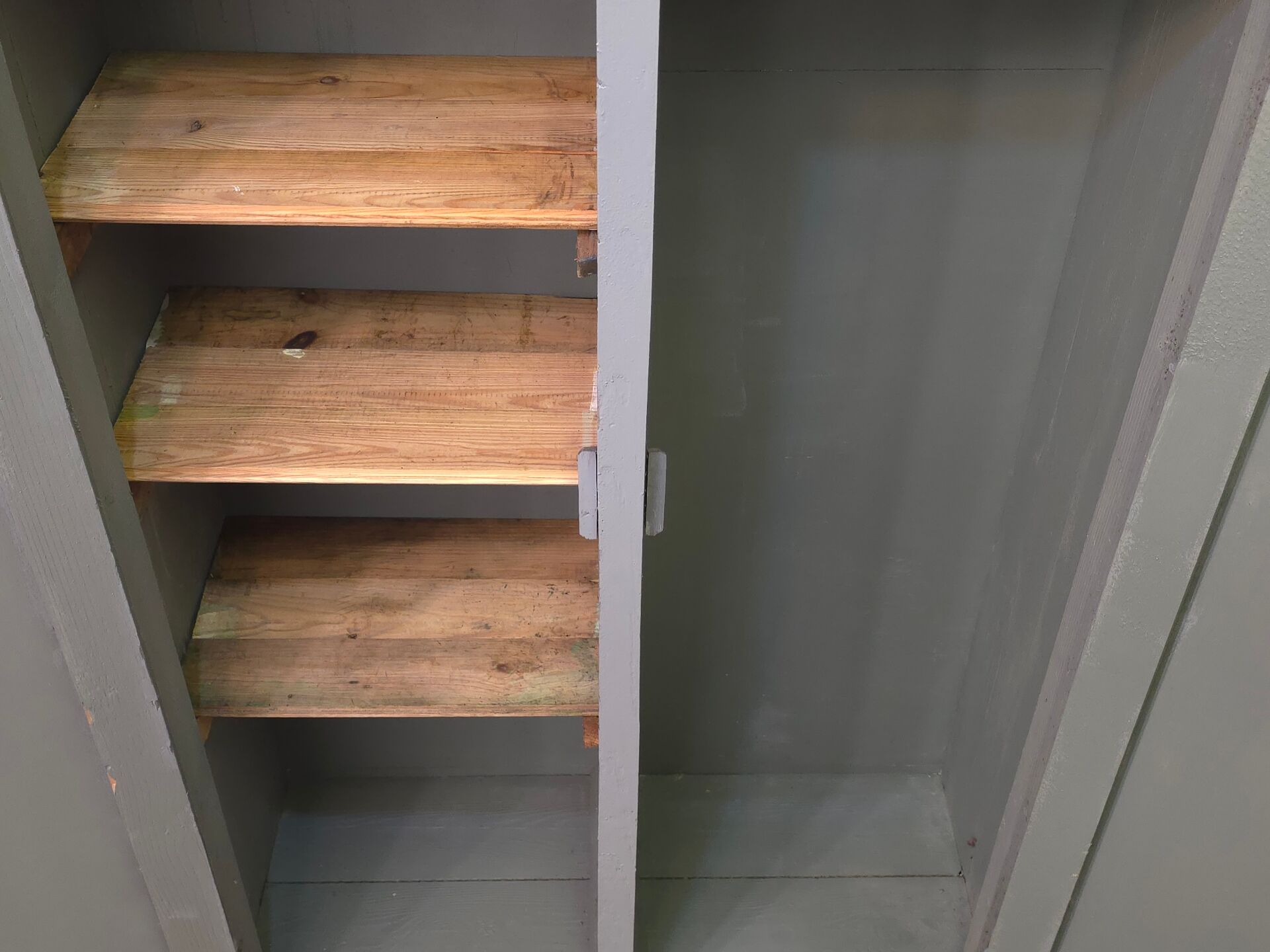 Curved wardrobe workshop locker made of wood repainted in grey.