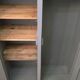 Curved wardrobe workshop locker made of wood repainted in grey.