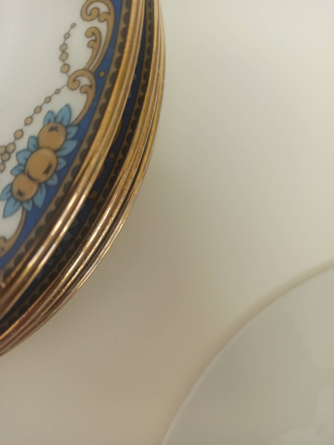 12 assiettes en porcelaine de Limoges à décor de guirlandes et de fruits