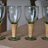 Four stemmed glasses surrounded by rattan.
