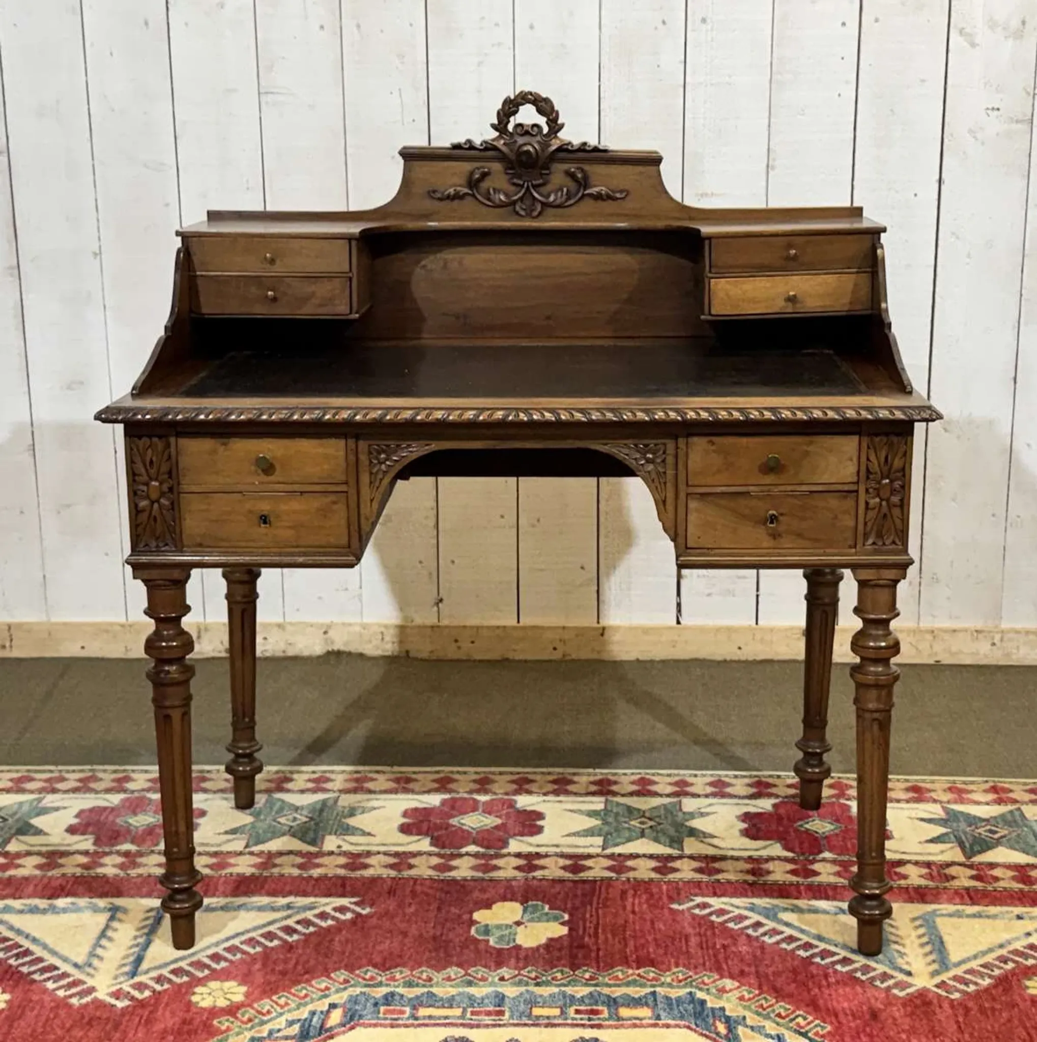 Louis XVI style desk from the late 19th century in walnut with a leather top.