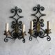 Pair of wall sconces in wrought iron with golden leaf patterns.