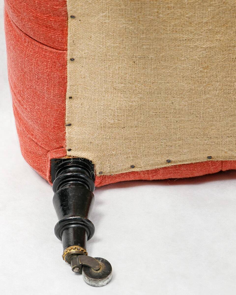 Napoleon III salon armchair in brick red linen with a tufted footrest.