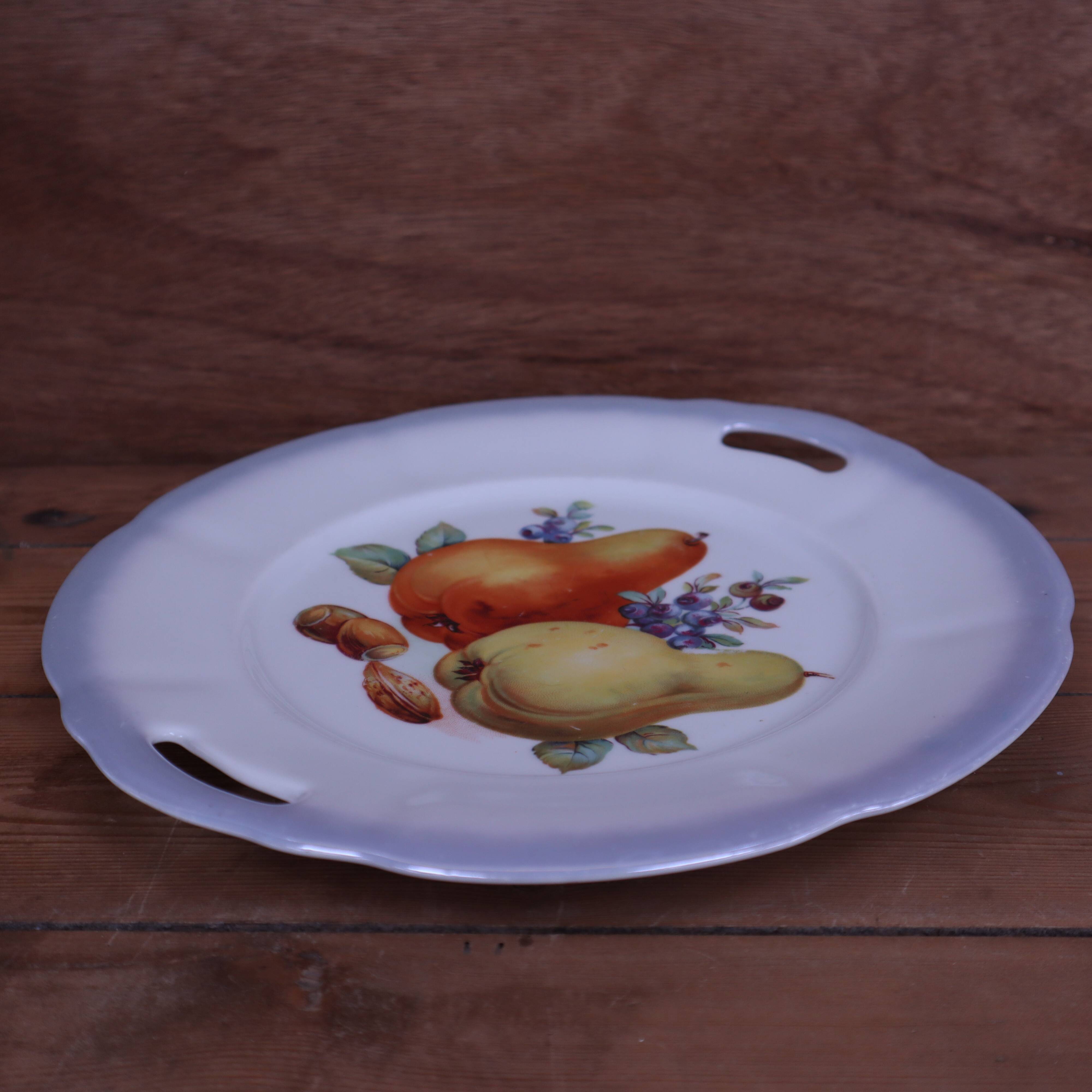Set of 7 dessert plates and a cake stand with fruit patterns.